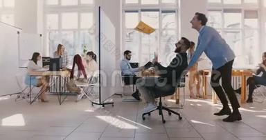 多利拍摄了疯狂有趣的商人骑着办公椅沿着办公大厅，庆祝和扔纸在空中。